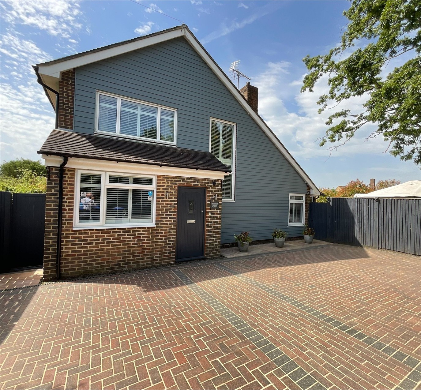 Complete front view of Ashcombe Lodge, including its roof and driveway